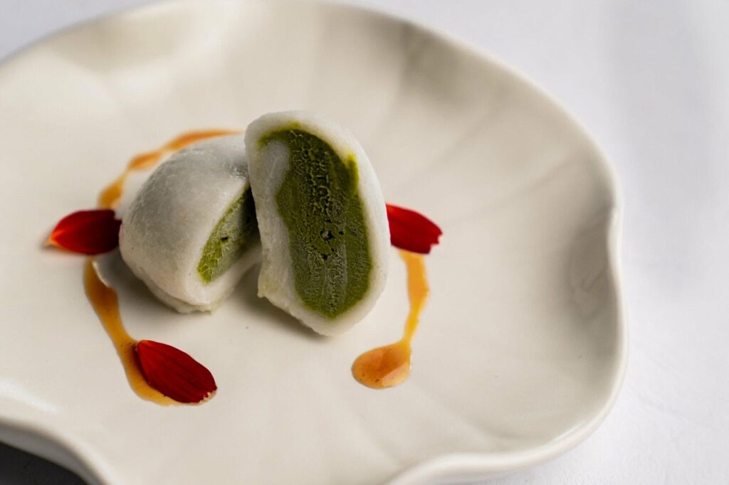 Image of Mochi Ice Cream, a traditional Japanese dessert from The Orchid Duck, a Japanese restaurant in Ubud. It consists of chewy mochi rice cake filled with green tea flavored ice cream.